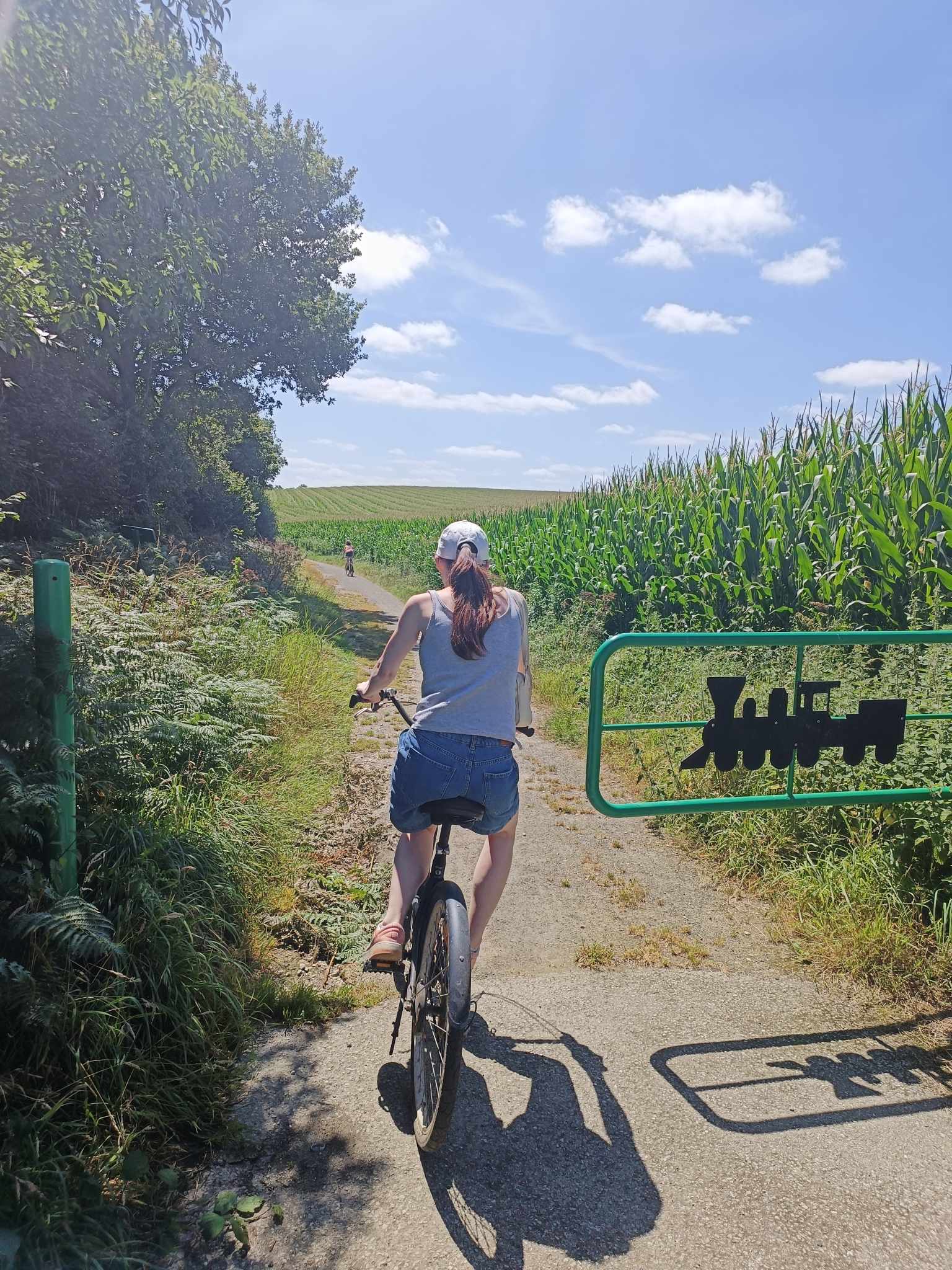 Personne a vélos sur la voie verte qui longe le terrain du manoir